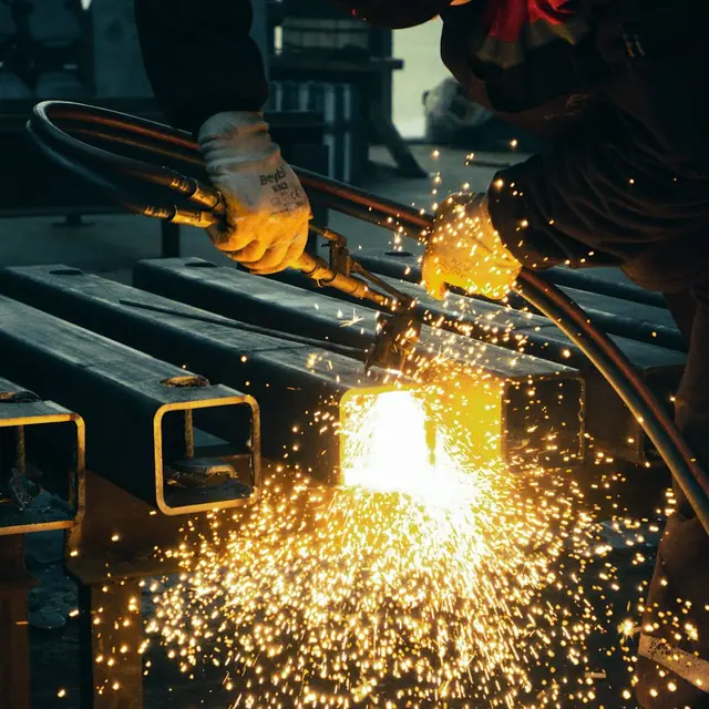 Corte de tubos de acero con chispas para una estructura metálica