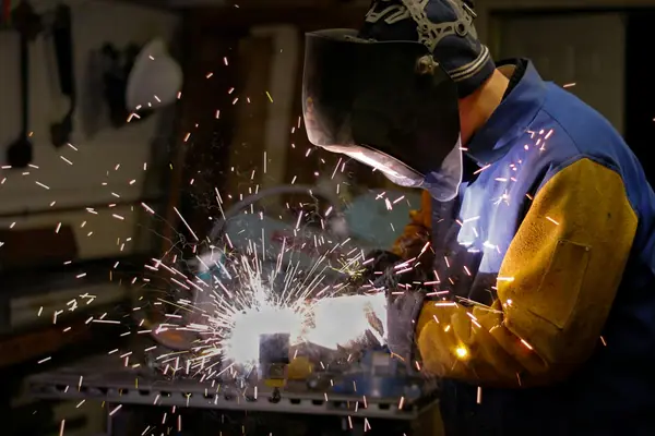 Técnico con equipo de protección haciendo mantenimiento a una máquina