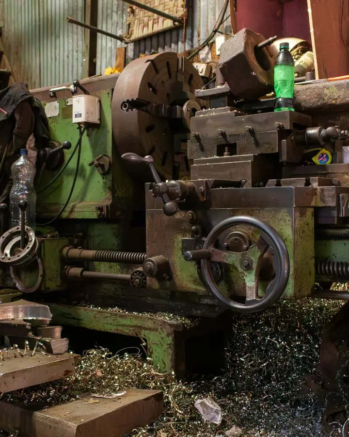 Torno industrial dentro de un taller metalmecánico, rodeado de virutas de metal